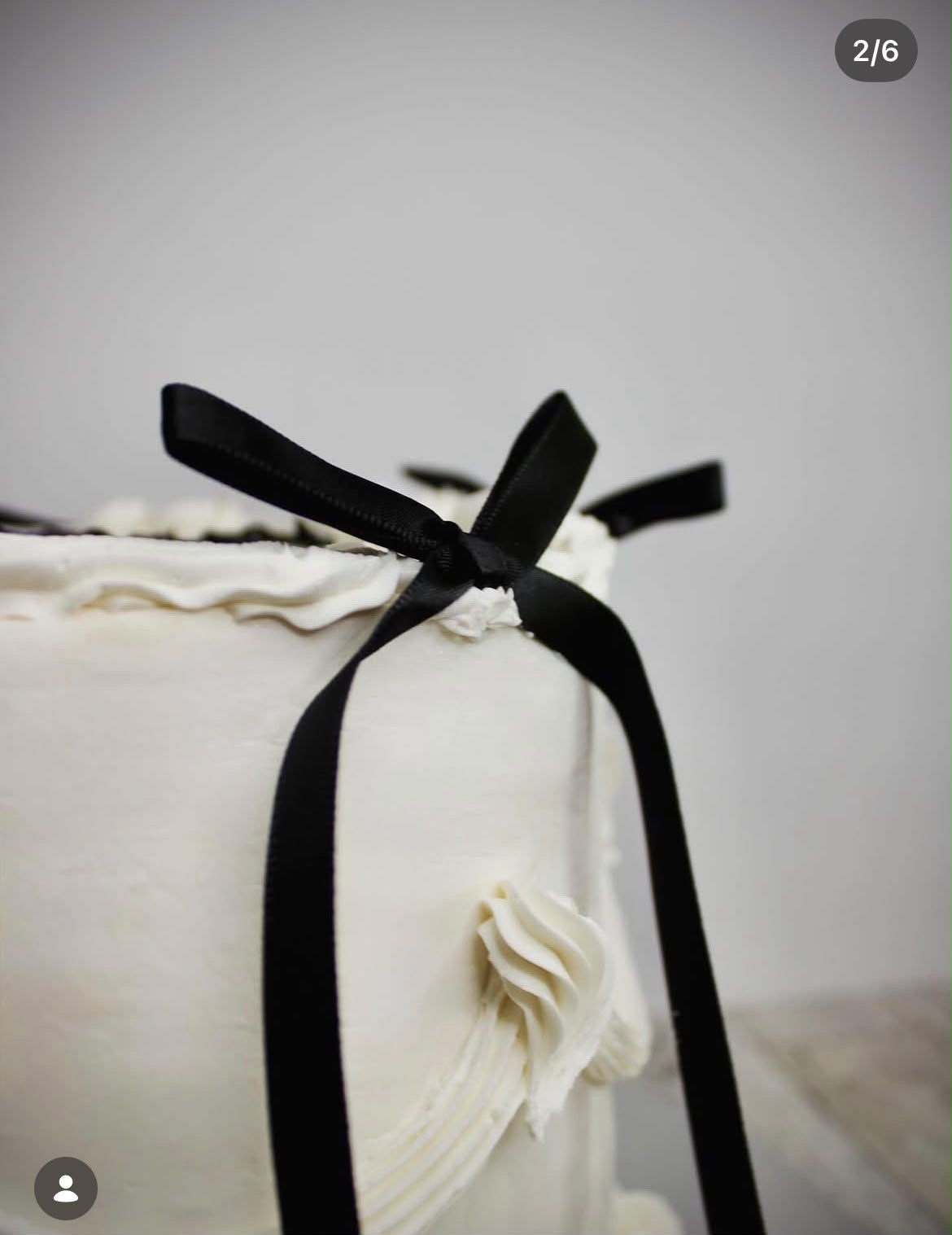 Detalle de los lazos negros en un pastel blanco